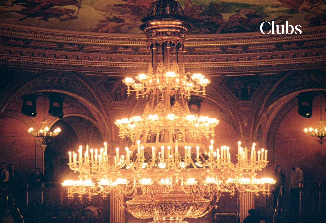 A chandelier lit up inside an opera house
