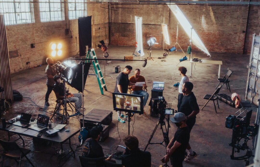 A small film crew at work on a warehouse set