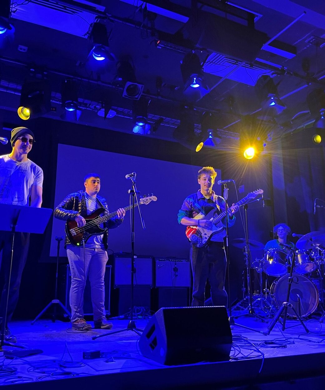 A band playing on stage under blue lights